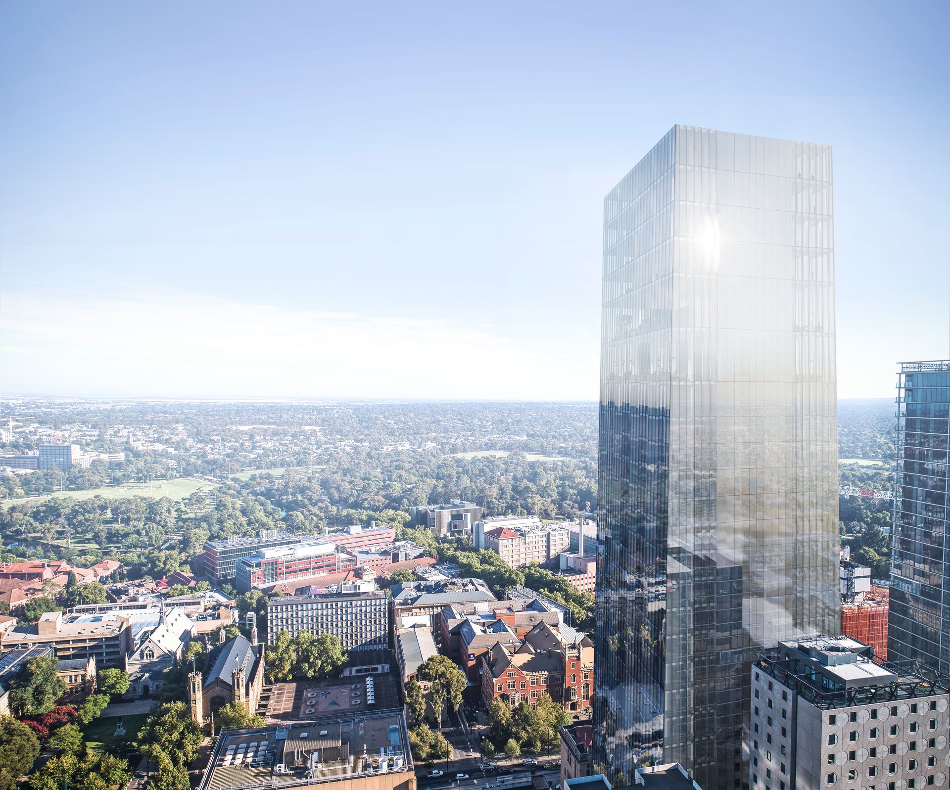Glass tower above a low-rise city grid
