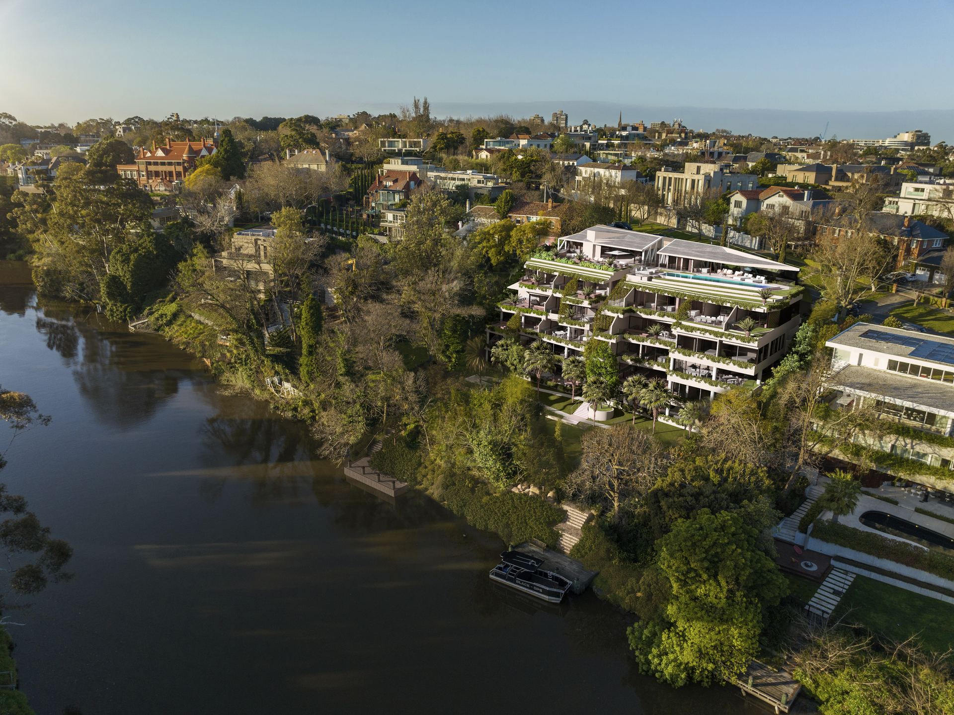 Aerial view of a terraced residential building beside a river